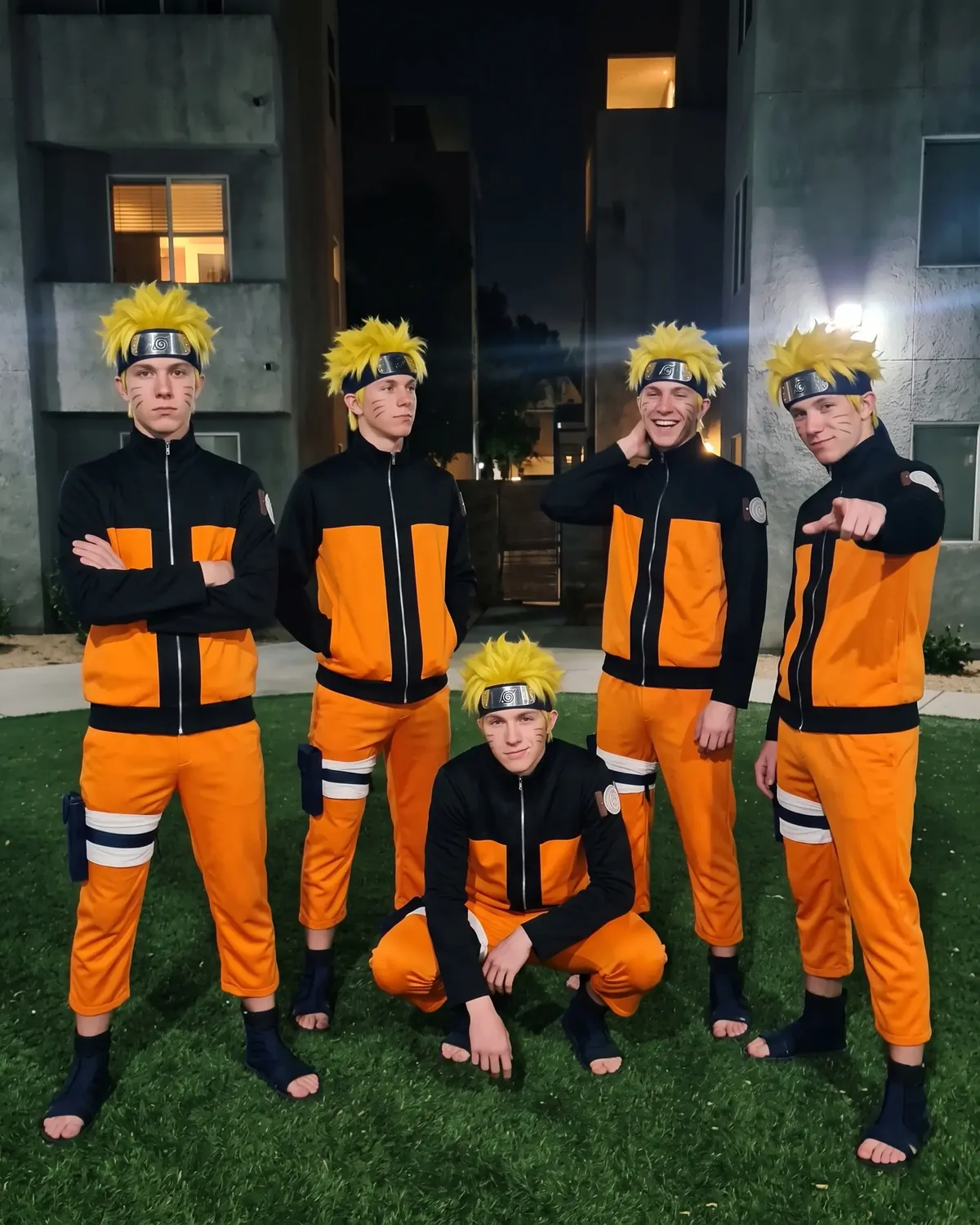 Five identical Naruto IRLs posing together on the courtyard grass at night