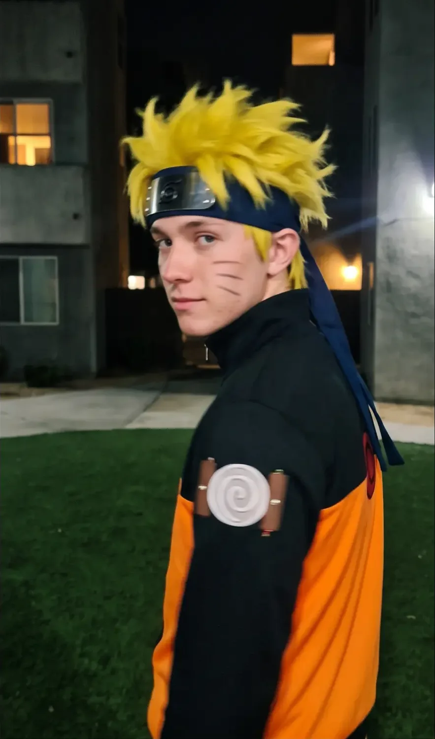 Naruto IRL from the side, glancing back, the swirl patch on his sleeve